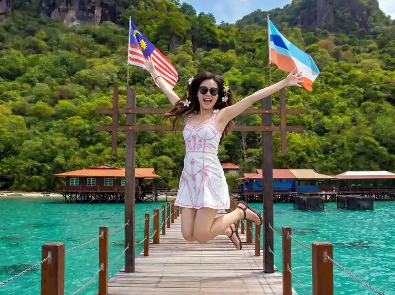 Hiking Bohey Dulang peak for panoramic lagoon views with Parapat Water Village Resort in the Celebes Sea.