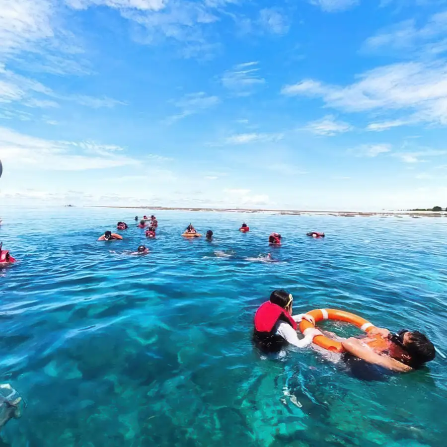 Guests snorkelling in the clear shallow waters near Parapat Water Village Resort