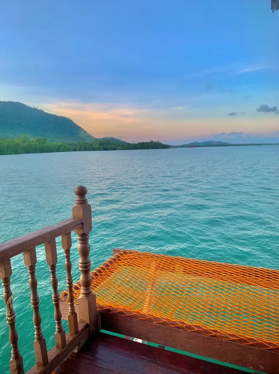 Private sun-drenched balcony with an overwater hammock net at Parapat Water Village Resort. An intimate over the water escape offering scenic views of neighboring chalets and the Semporna ocean.